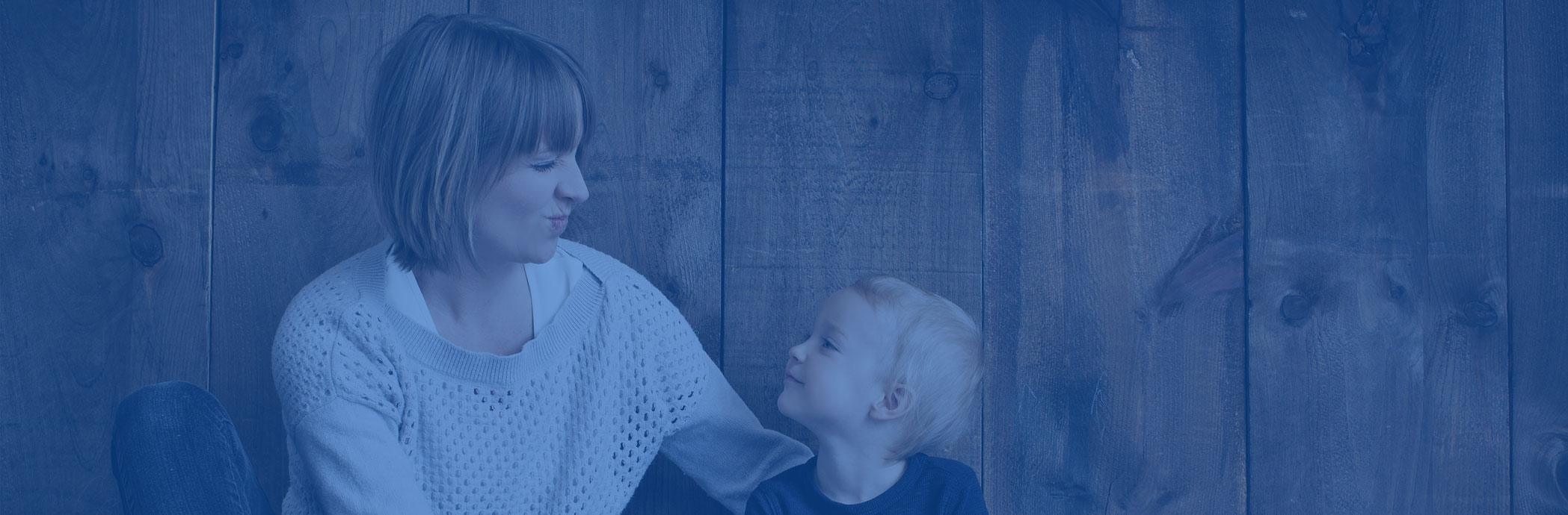 Woman and child against a wood wall.